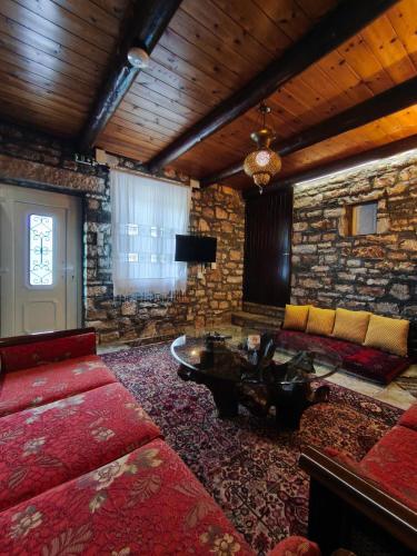 a living room with a couch and a table at HerbStone Lodges in Asprangeloi