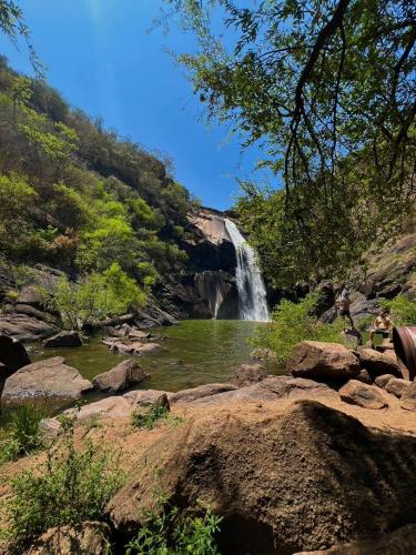 a waterfall in the middle of a river with rocks at Fusca Home in Piedade