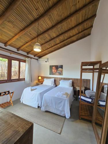 a bedroom with two beds in a room at Tawa Caraíva in Caraíva