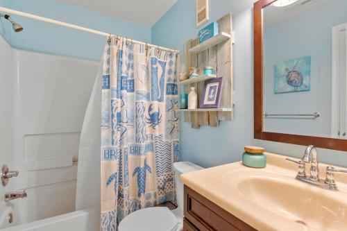 a bathroom with a sink and a shower curtain at Sandpiper Cay 706 in Kitty Hawk