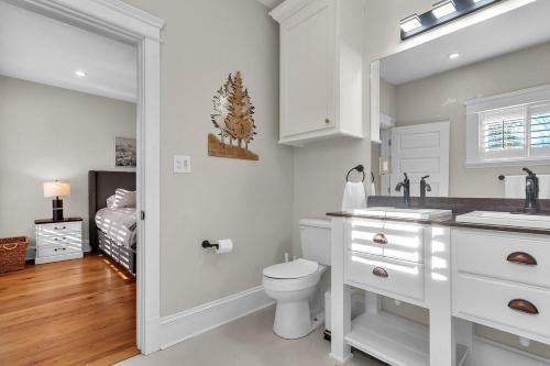 a white bathroom with a toilet and a sink at The Park House in Batesville
