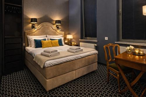 a bedroom with a bed and a desk and a table and a desk at Cocorico Bed and Breakfast OLD TOWN Szczecin Adults Only in Szczecin