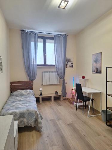a bedroom with a bed and a desk and a window at B&B Siena Le Grondaie in Siena