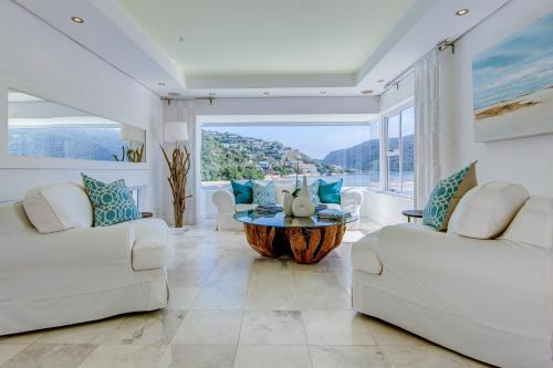 a living room with white furniture and a large window at Amanzi Island Boutique Hotel in Knysna