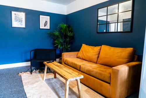 a living room with a brown couch and a table at 4 BD Sleeps 7 Parking WiFi in Coventry