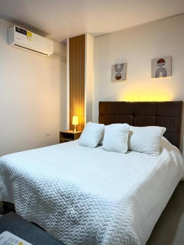 a bedroom with a large bed with white sheets and pillows at Amazonía Luxury Loft 203 in Florencia
