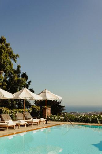 a swimming pool with chairs and umbrellas at El Encanto Santa Barbara in Santa Barbara