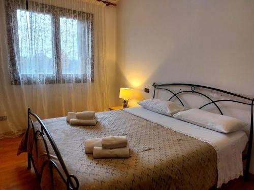 a bedroom with a bed with two towels on it at La Casa di M : D M. in Breda di Piave