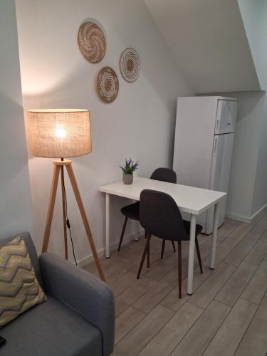 a living room with a table and chairs and a refrigerator at Casa do Hilário in Viseu