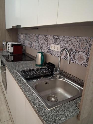 a kitchen counter with a sink and a microwave at Casa do Hilário in Viseu