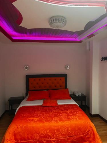 a bedroom with a bed with purple lights on the ceiling at Hotel Tropical Club in Estación El Salto