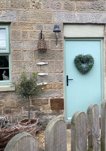 a front door of a brick house with a blue door at Hideaway Cottage in Whitby
