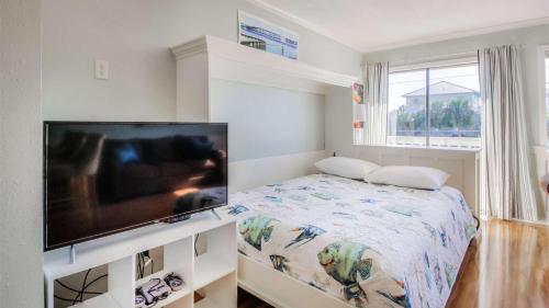 a bedroom with a flat screen tv and a bed at Canal Place 206 in Destin