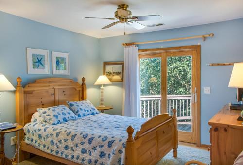 a bedroom with a bed and a balcony at Dragonfly in Southern Shores