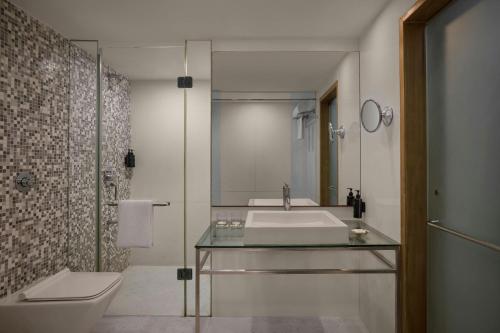 a bathroom with a sink and a toilet at The Fern Residency Ahmedabad, Subhash Bridge, Series by Marriott in Ahmedabad