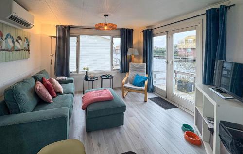 a living room with a couch and a tv at Chalet in Breukelen