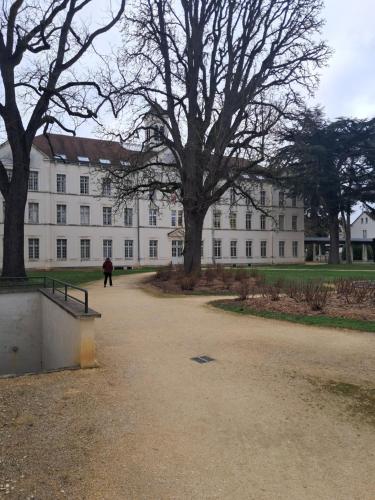 a person walking in front of a large white building at Pierres, cloches et vignes in Auxerre