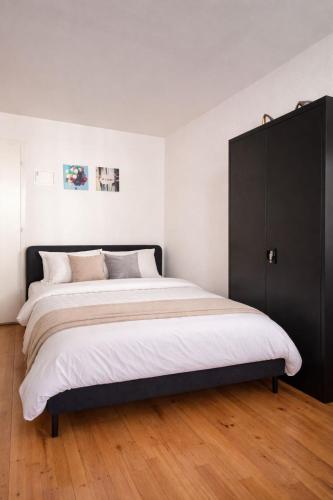 a bedroom with a large bed with a black cabinet at Central & Tranquil by Cathedral in Fribourg