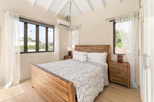 a bedroom with a large bed and windows at Mullins Bay View - 4 Bed - Sea View, Infinity Pool in Saint Peter