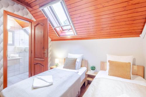 two beds in a room with a skylight at Easy Sleep - Comfy Stay in Soltvadkert