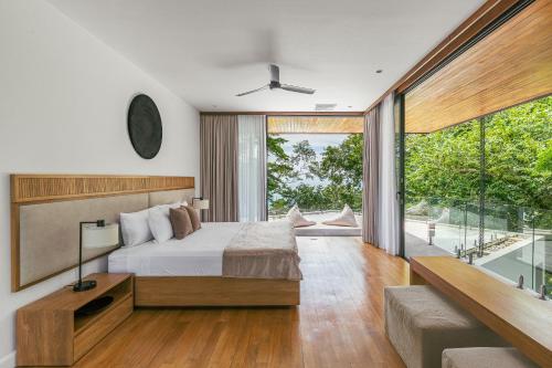 a bedroom with a bed and a large window at Tenowi Villa in Mal País