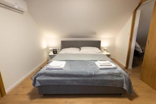 a bedroom with a large bed with towels on it at Timber Home in Veliko Trgovišće