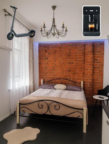 a bedroom with a bed and a brick wall at Kaunas Studios - RentA 18 in Kaunas