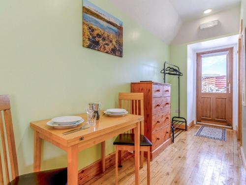 a dining room with a wooden table with plates on it at Quinag Studio Apartment - Uk49098 in Inchnadamph