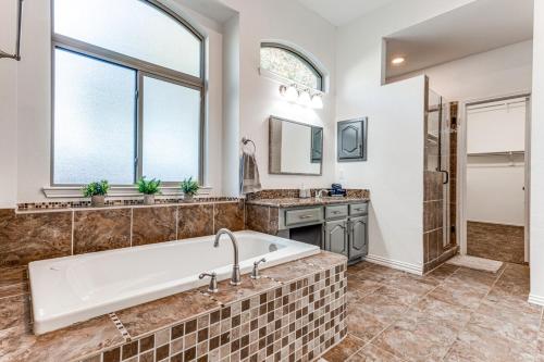 a large bathroom with a tub and a shower at 5Br Lux! Pool, Games & Theater in Rowlett