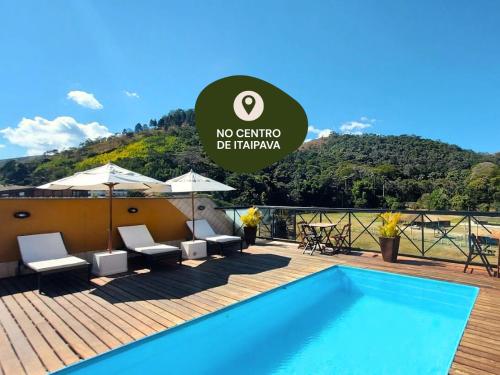 a villa with a swimming pool on a wooden deck at Kastel Itaipava in Itaipava