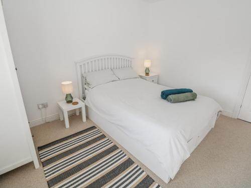 a bedroom with a large white bed with two lamps at Win Hill View in Bamford