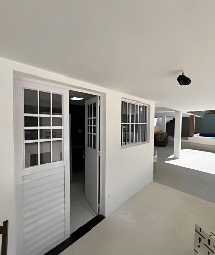 a room with white walls and sliding doors at PARAISO A BEIRA Mar de Antunes, conforto,Piscina,Mar e Natureza in Maragogi