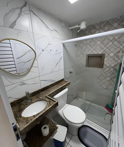 a bathroom with a toilet and a sink and a mirror at PARAISO A BEIRA Mar de Antunes, conforto,Piscina,Mar e Natureza in Maragogi