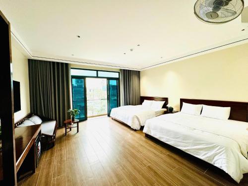 a hotel room with two beds and a television at An's Home Ninh Binh in Ninh Binh