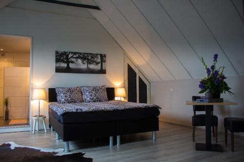 een slaapkamer met een bed en een tafel met bloemen erop bij Sistazz Bed&Breakfast in Bussloo