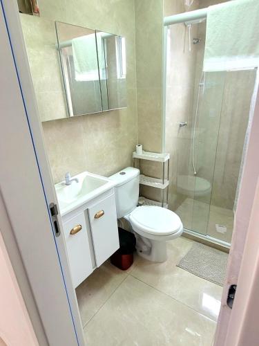 a bathroom with a toilet and a sink and a shower at Apartamento com estacionamento in Uruguaiana