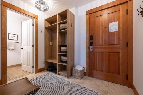 a hallway with a wooden door and shelves at Fully Renovated Penthouse Loft at Fernie Alpine Resort in Fernie