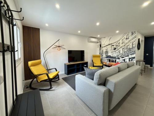 a living room with a couch and yellow chairs at Alma do Tejo - Alma Nossa in Montijo