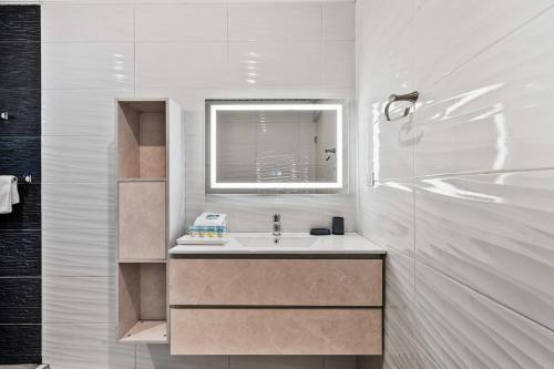 a white bathroom with a sink and a window at Salinja Cerca 2-B in Palm-Eagle Beach