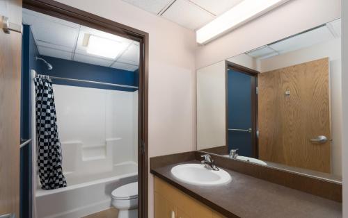 a bathroom with a sink and a toilet and a mirror at Brewster Hall in Cheney