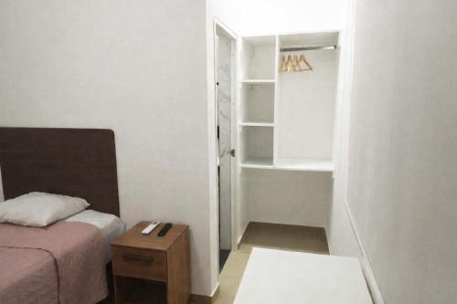 a small room with a bed and a book shelf at La casa de Isabel in Tarapoto