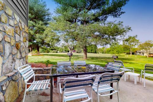 a patio with a table and chairs and a stone wall at Inviting & Cozy Studio Sleep 4 Shared Gym & Games in Baneberry