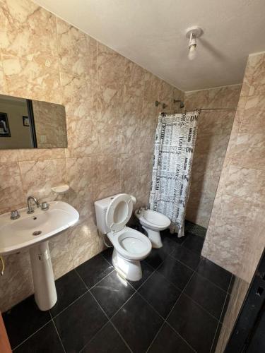 a bathroom with a toilet and a sink at Complejo El Teyu in Miramar