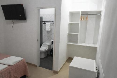 a small bathroom with a toilet and a television at La casa de Isabel in Tarapoto