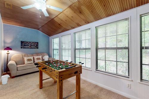a living room with a foosball table in front of a couch at Charming Condo Sleeps 6 Shared Pool Gym Fireplace in Gatlinburg