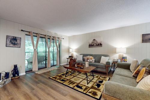 a living room with a couch and a table at Charming Condo Sleeps 6 Shared Pool Gym Fireplace in Gatlinburg