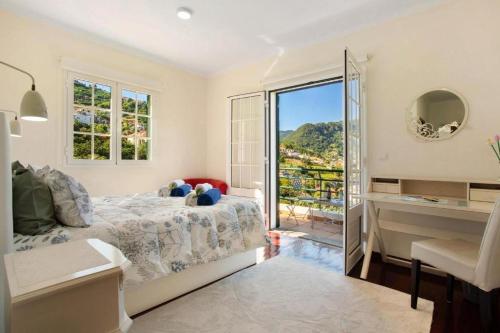 a bedroom with a bed and a window with a view at traveller's house PROMO 25 in Machico