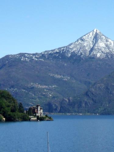 a mountain with a house in the middle of a lake at Garden Rooms 1 in Menaggio