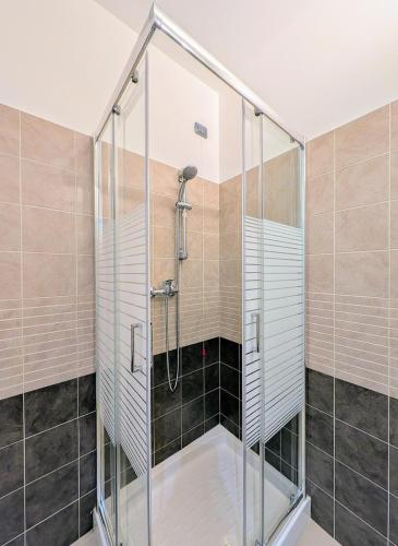 a shower with a glass door in a bathroom at Appartamento Via Filatoio 9 in Domaso