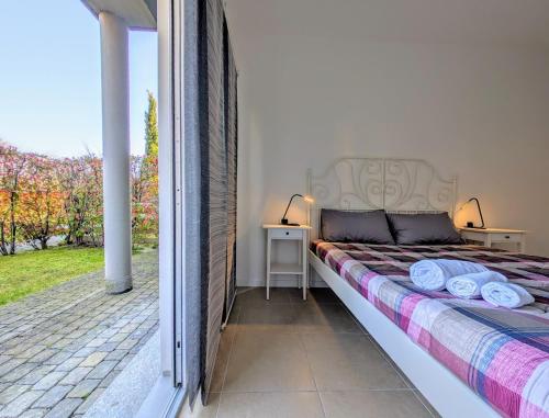 a bedroom with a bed and two tables and a window at Appartamento Via Filatoio 9 in Domaso